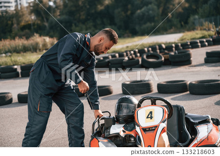 Starting the vehicle. Man is outdoors, kart racing conception 133218603