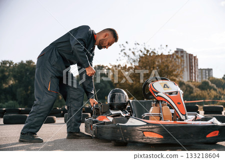 Starting the vehicle. Man is outdoors, kart racing conception 133218604