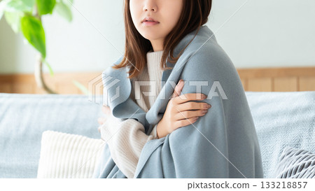 A woman who feels cold and puts on a blanket 133218857