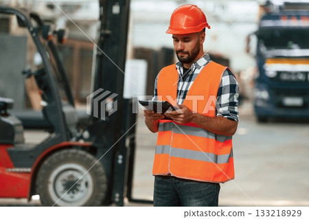 Manager is with digital tablet. Industrial worker in wooden warehouse 133218929