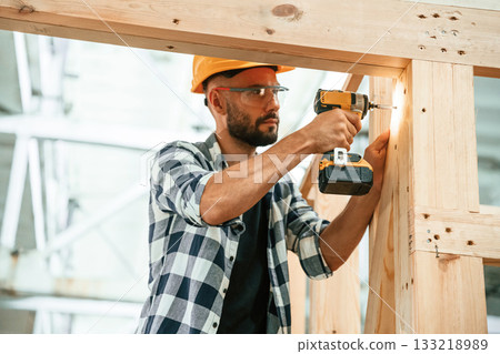 Busy, drilling the hole. Industrial worker in wooden warehouse Busy, drilling the hole. Industrial worker in wooden warehouse 133218989