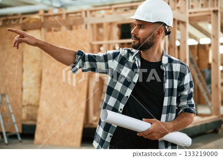 Giving the orders by hand gesture. Industrial worker in wooden warehouse Giving the orders by hand gesture. Industrial worker in wooden warehouse 133219000