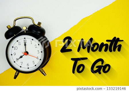2 Month To Go text and alarm clock on yellow background 2 Month To Go text and alarm clock on yellow background 133219146