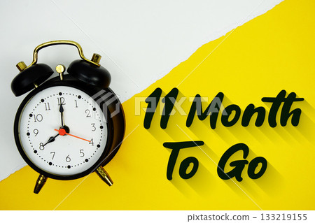 11 Month To Go text and alarm clock on yellow background 11 Month To Go text and alarm clock on yellow background 133219155