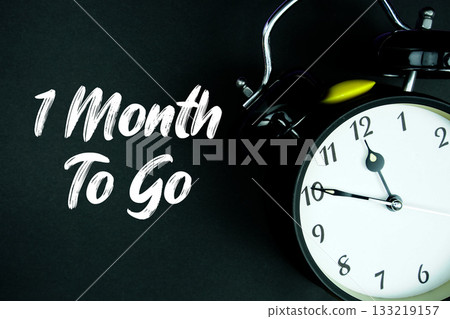 1 Month To Go text and alarm clock on black background 133219157