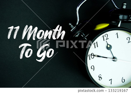 11 Month To Go text and alarm clock on black background 11 Month To Go text and alarm clock on black background 133219167