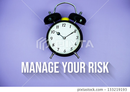Manage Your Risk text and alarm clock on purple background 133219193