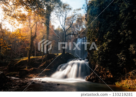 Ancient monastery nestled in autumn forest landscape under blue sky. Monasterio de Piedra 133219281