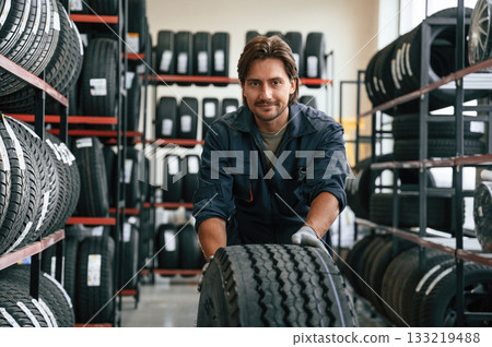 Man is in the tire fitting car service Man is in the tire fitting car service 133219488