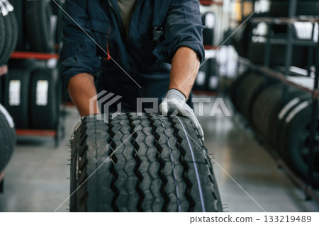 Rolling the wheel. Man is in the tire fitting car service 133219489