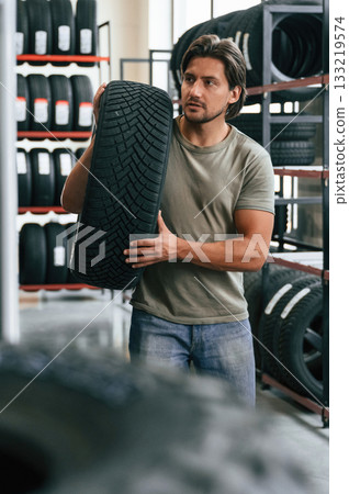 Man is in the tire fitting car service Man is in the tire fitting car service 133219574