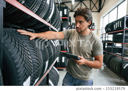 Quality control, manager is looking for stuff. Man is in the tire fitting car service Quality control, manager is looking for stuff. Man is in the tire fitting car service 133219579