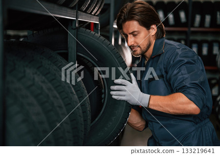 In the warehouse. Man is in the tire fitting car service 133219641