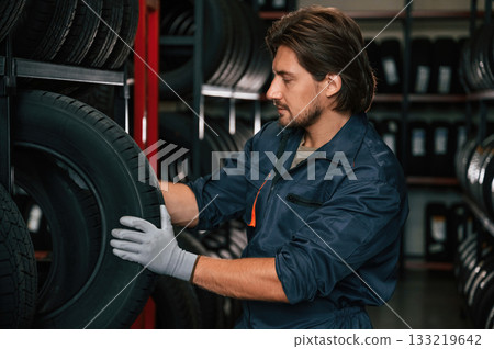 In the warehouse. Man is in the tire fitting car service 133219642