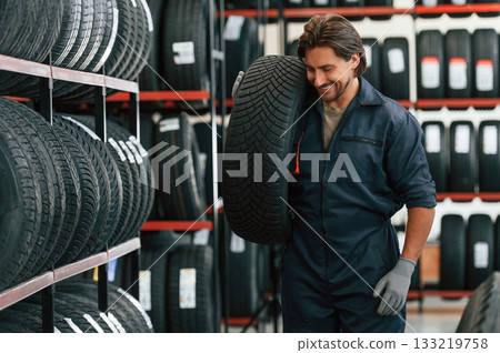 Cheerful, smiling. Man is in the tire fitting car service 133219758