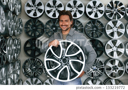 Disk in hands. Man is in the tire fitting car service Disk in hands. Man is in the tire fitting car service 133219772
