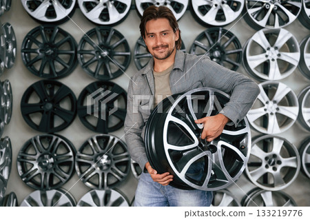 Big choice. Man is in the tire fitting car service Big choice. Man is in the tire fitting car service 133219776