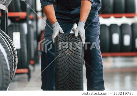 Detailed close up view, moving the wheel. Man is in the tire fitting car service Detailed close up view, moving the wheel. Man is in the tire fitting car service 133219783