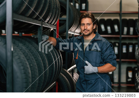 In professional uniform. Man is in the tire fitting car service 133219803