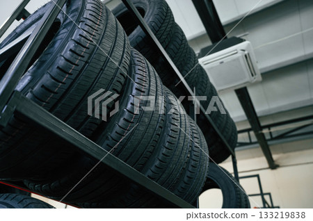 On the shelves. New tires are placed on the storage rack in the car workshop 133219838