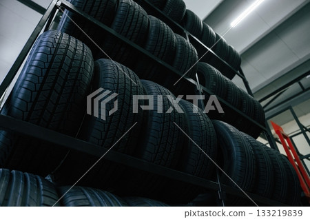 On the shelves. New tires are placed on the storage rack in the car workshop 133219839
