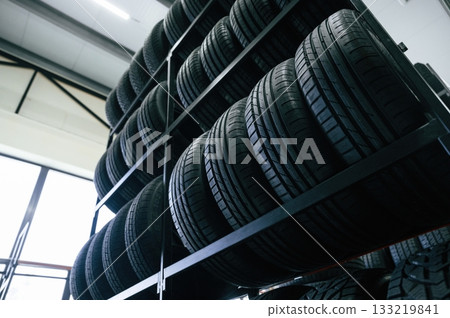 On the shelves. New tires are placed on the storage rack in the car workshop 133219841