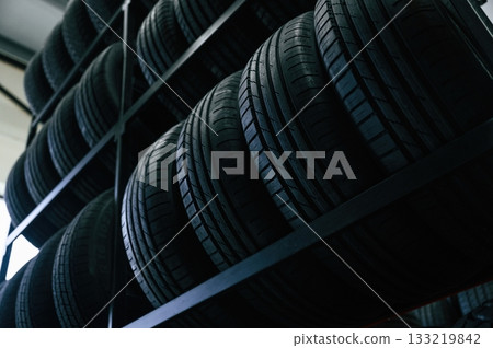 On the shelves. New tires are placed on the storage rack in the car workshop 133219842