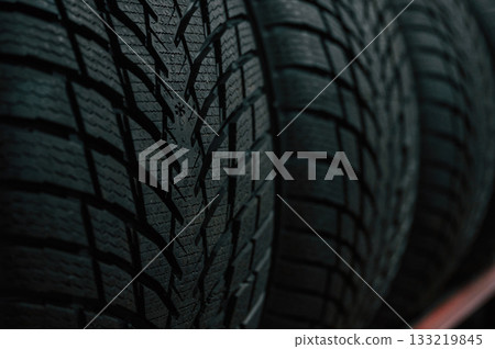 Particle close up view. New tires are placed on the storage rack in the car workshop 133219845