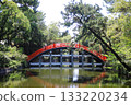 A red arched bridge over a pond 133220234