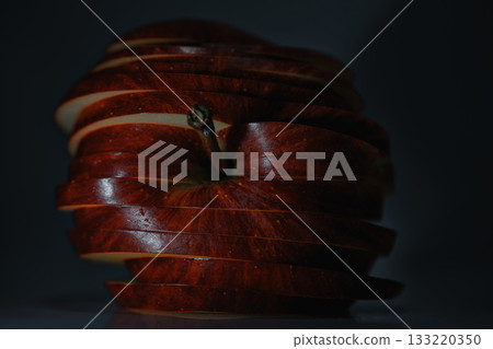 creative food art emphasizing layered apple slices with contrasting lighting effects and shadows 133220350