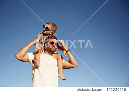 Against sky, in sunglasses, pilots. Father and son are together on the field Against sky, in sunglasses, pilots. Father and son are together on the field 133220636