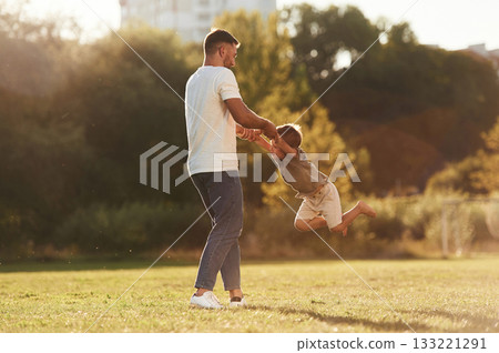 Holding hands, rotating. Father and son are together on the field 133221291