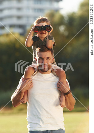 Looking through the binocular. Father and son are together on the field 133221298