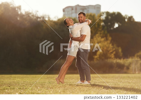 Embracing each other. Lovely couple are having a walk on the field Embracing each other. Lovely couple are having a walk on the field 133221402