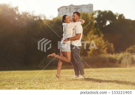 Embracing each other. Lovely couple are having a walk on the field Embracing each other. Lovely couple are having a walk on the field 133221403