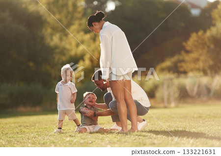 Parents with two little sons are on the field together Parents with two little sons are on the field together 133221631