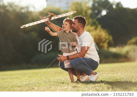Joy, fun, weekend activities. Father and son are on the field together with toy plane Joy, fun, weekend activities. Father and son are on the field together with toy plane 133221783