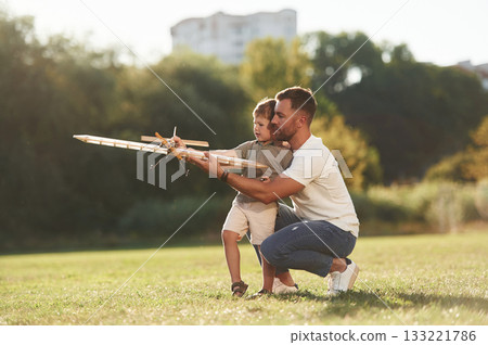 Joy, fun, weekend activities. Father and son are on the field together with toy plane 133221786