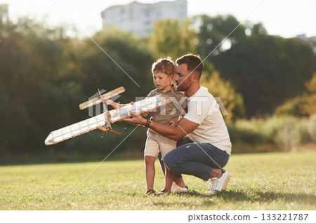 Joy, fun, weekend activities. Father and son are on the field together with toy plane Joy, fun, weekend activities. Father and son are on the field together with toy plane 133221787