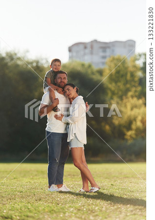 Three people. Mother and father are with son outdoors on the field Three people. Mother and father are with son outdoors on the field 133221830