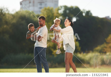Husband and wife. Parents with two little sons are on the field together Husband and wife. Parents with two little sons are on the field together 133221941