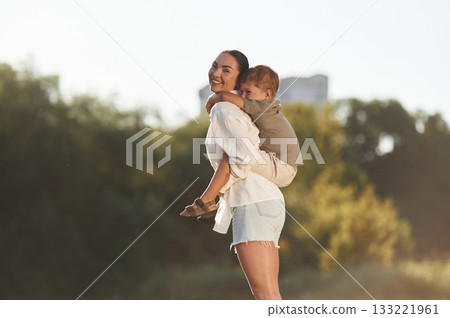 Woman with her little son are on the field together Woman with her little son are on the field together 133221961