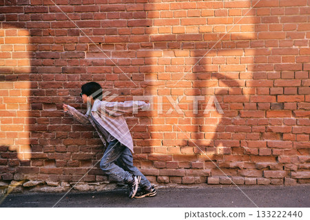 The boy runs away from the shadow on the wall The boy runs away from the shadow on the wall 133222440
