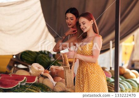 Smiling, standing. Two women are together on the marker or bazaar Smiling, standing. Two women are together on the marker or bazaar 133222470