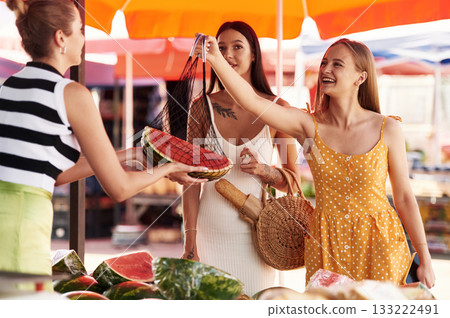 Red fresh watermelon. Two women are together on the marker or bazaar Red fresh watermelon. Two women are together on the marker or bazaar 133222491
