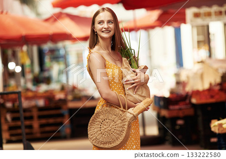 With spring onion. Young woman is on the vegetable market or bazaar With spring onion. Young woman is on the vegetable market or bazaar 133222580