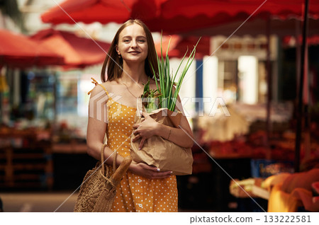 Spring onion, front view. Young woman is on the vegetable market or bazaar 133222581