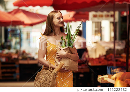 Spring onion, front view. Young woman is on the vegetable market or bazaar 133222582