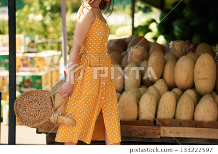 Focused close up view. Young woman is on the vegetable market or bazaar Focused close up view. Young woman is on the vegetable market or bazaar 133222597