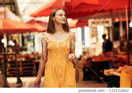Walking around. Young woman is on the vegetable market or bazaar Walking around. Young woman is on the vegetable market or bazaar 133222602